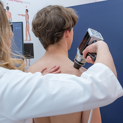 Detailaufnahme: Dermatologin positioniert die Patientin präzise für die ATBM master Ganzkörperaufnahme.